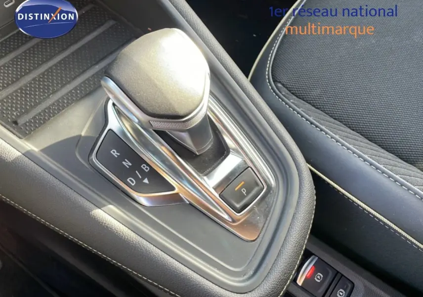 Gros plan sur la commande de boîte automatique de la Renault Symbioz 2025, avec sellerie tissu noire et surpiqûres blanches.