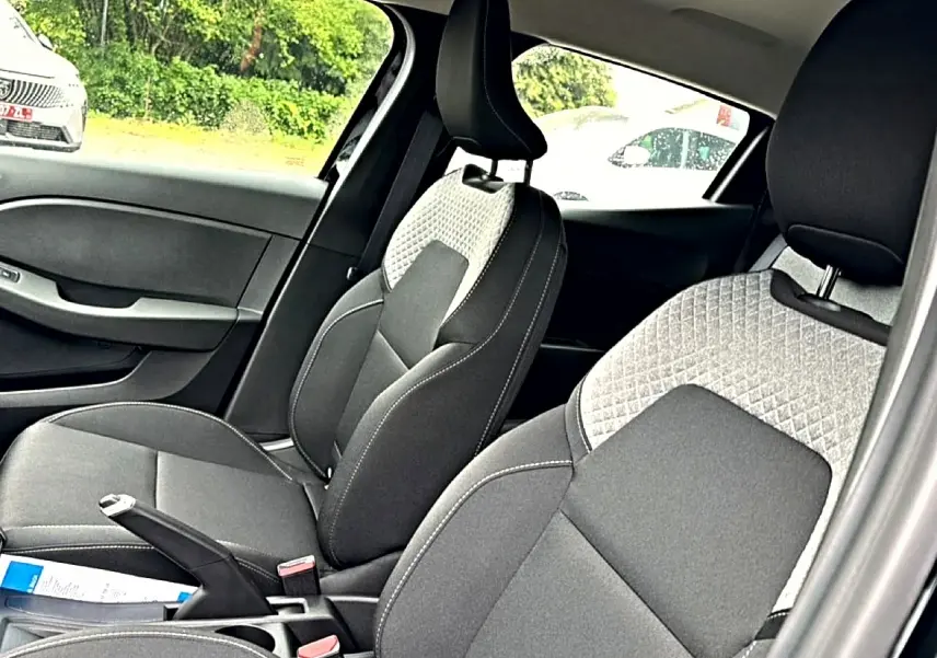 Vue intérieure côté droit montrant les sièges avant gris et noirs de la Renault Clio V 2026.