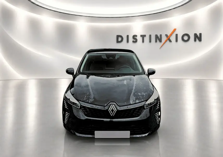 Renault Clio V noire vue de face, avec calandre distinctive et éclairage LED dans un showroom lumineux.