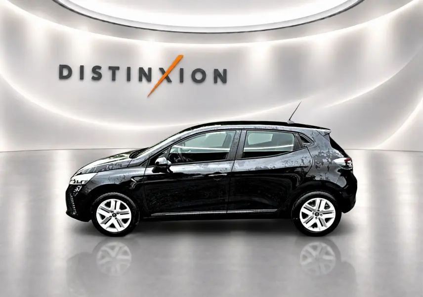 Profil côté gauche d'une Renault Clio V noire, avec jantes argentées, dans un showroom lumineux au sol réfléchissant.