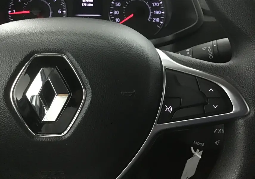Gros plan sur le volant noir du Renault Express Van 2021 avec commandes intégrées et logo chromé central.