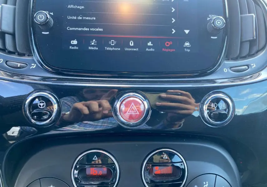 Vue rapprochée de la console centrale noire du Fiat 500 2024, avec écran tactile et commandes climatisation.
