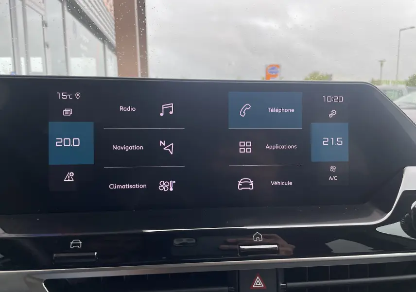 Écran tactile central de la Citroën C4 blanche 2022 affichant les options radio, navigation, téléphone et climatisation.