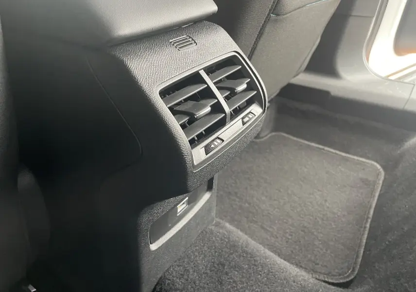Gros plan sur la sortie d'air arrière et prise USB dans l'habitacle noir du Citroën C4 1.2 PureTech 130 Shine 2022.