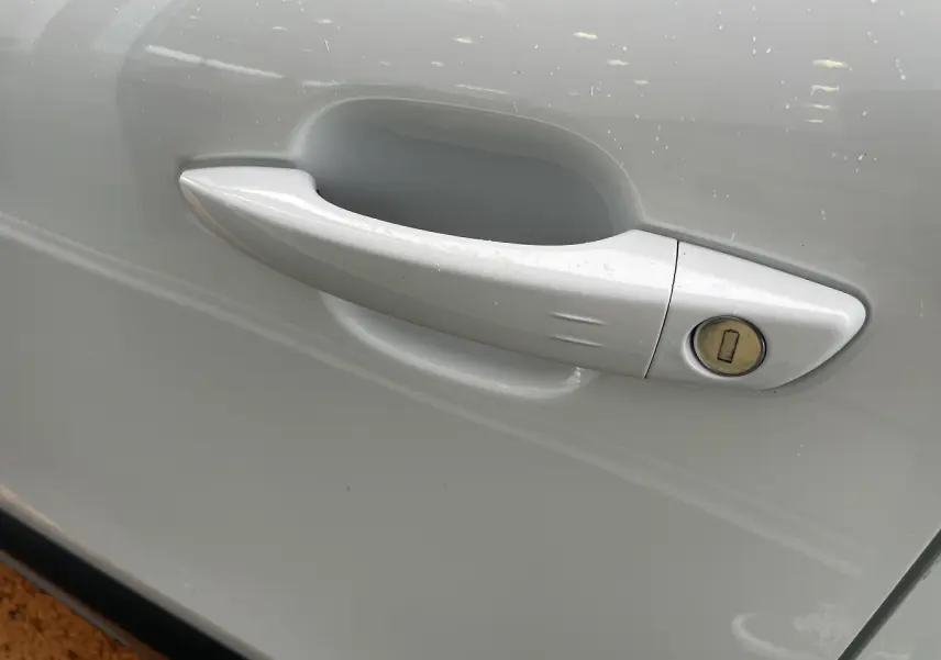 Poignée de porte blanche côté droit de la Citroën C4 1.2 PureTech 130 Shine avec serrure intégrée.