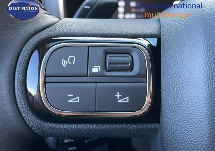 Gros plan sur les commandes au volant du Citroën C5 Aircross noir Perla Metal, avec boutons de réglage du volume et appels.