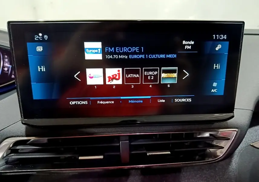 Écran tactile central affichant les stations radio, intérieur du Peugeot 3008 noir, vue rapprochée frontale.