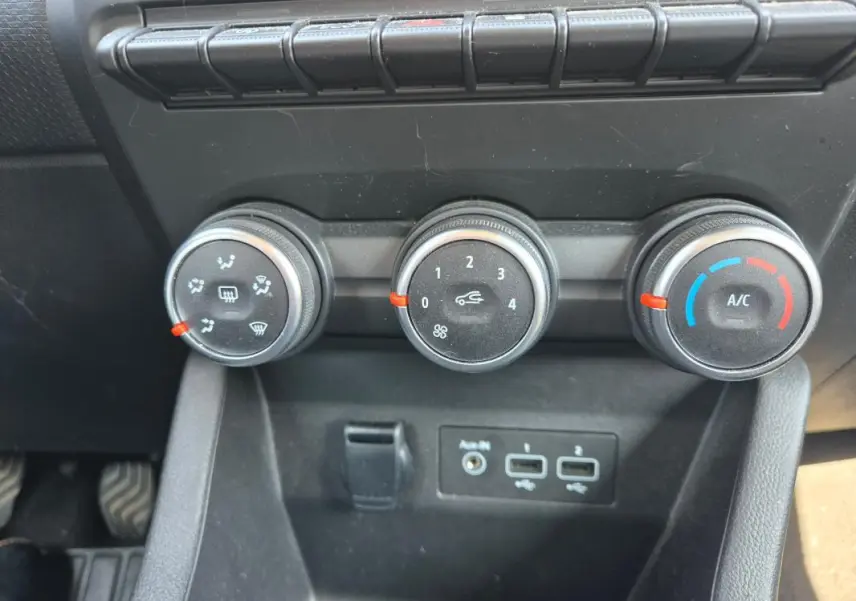 Vue rapprochée des commandes de climatisation manuelle et des ports USB dans une Renault Clio V TCe 90 noire de 2022.