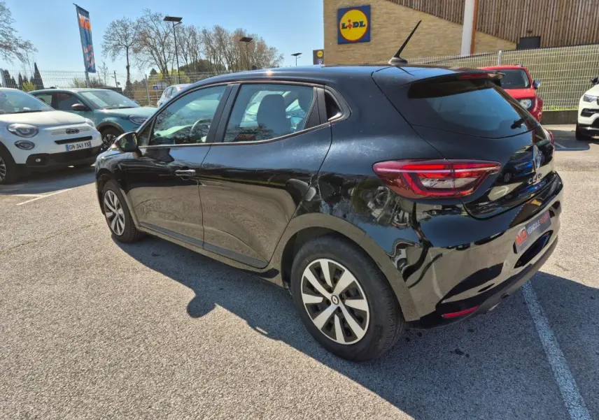 Vue 3/4 arrière droite d'une Renault Clio noire 2022 stationnée en extérieur, avec jantes alliage et vitres teintées.