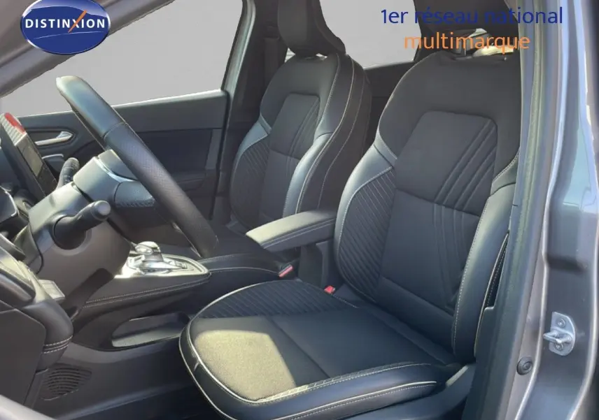Vue intérieure côté conducteur de la Renault Symbioz gris cassiopée, sièges noirs en tissu et cuir avec surpiqûres contrastées.