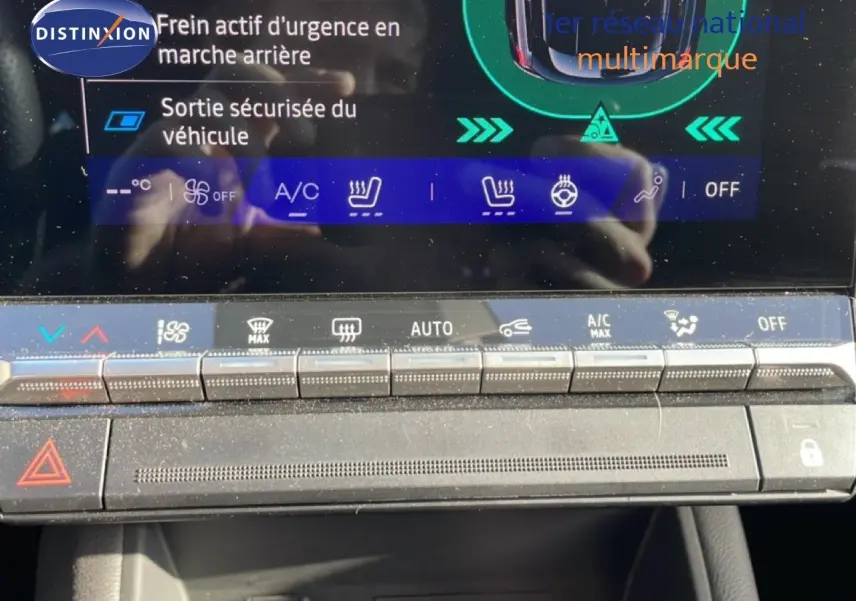 Gros plan sur la console centrale de la Renault Symbioz gris cassiopee, mettant en valeur les commandes climatisation et sécurité.