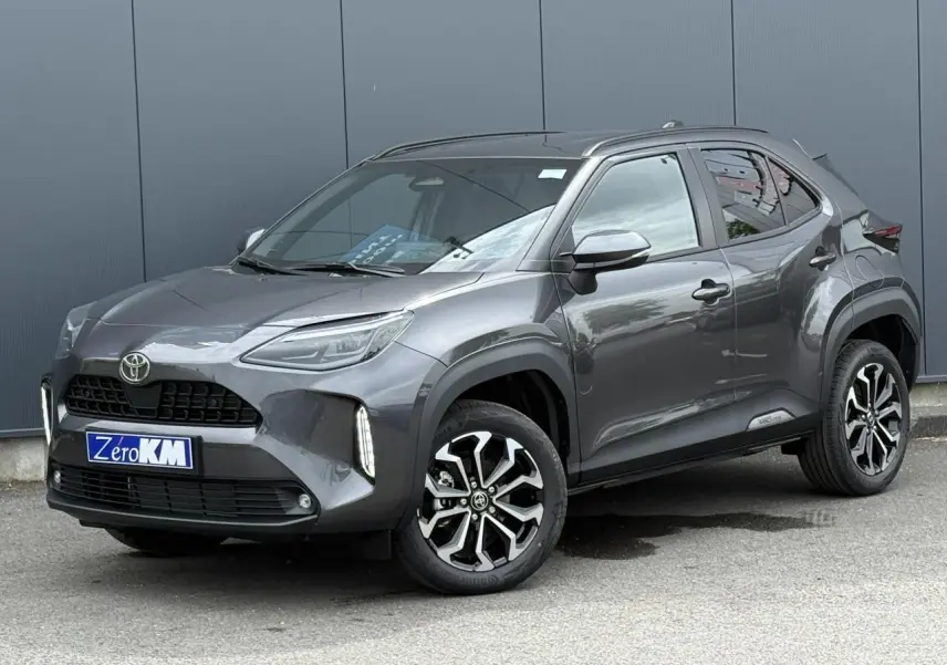 Toyota Yaris Cross gris Atlas vue 3/4 avant droit, avec jantes alliage noires et détails noirs contrastants.