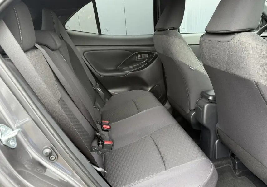 Vue intérieure côté gauche des sièges arrière gris foncé de la Toyota Yaris Cross 1.5 Hybrid 116 Design 2026.