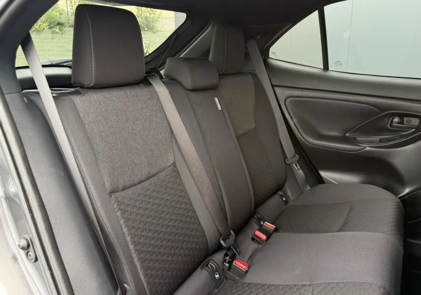 Vue intérieure côté droit des sièges arrière gris foncé de la Toyota Yaris Cross 1.5 Hybrid 2026 avec ceinture et appuie-tête.