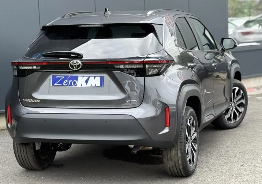 Vue 3/4 arrière droite du Toyota Yaris Cross gris Atlas avec feux arrière LED et jantes alliage noires.