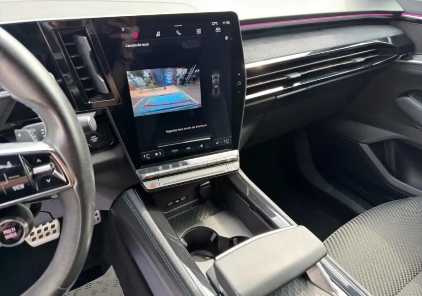 Vue intérieure côté conducteur du Renault Espace 2024 gris foncé, avec grand écran tactile central et volant multifonctions en cuir.