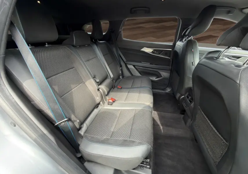 Vue latérale intérieure côté droit des sièges arrière gris foncé avec surpiqûres bleues du Renault Espace 2024 esprit Alpine E-Tech.