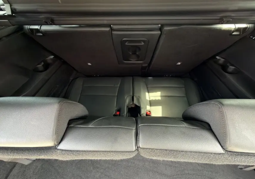 Vue plongeante sur la troisième rangée de sièges noirs rabattus du coffre du Renault Espace gris foncé 2024 esprit Alpine.