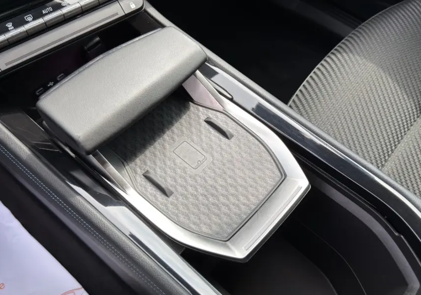 Vue rapprochée de la console centrale grise du Renault Espace 2024 esprit Alpine E-Tech avec zone de recharge sans fil.