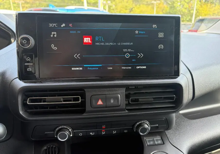 Vue rapprochée de l’écran tactile central du Peugeot Partner 2026 avec commandes de climatisation et ventilation.