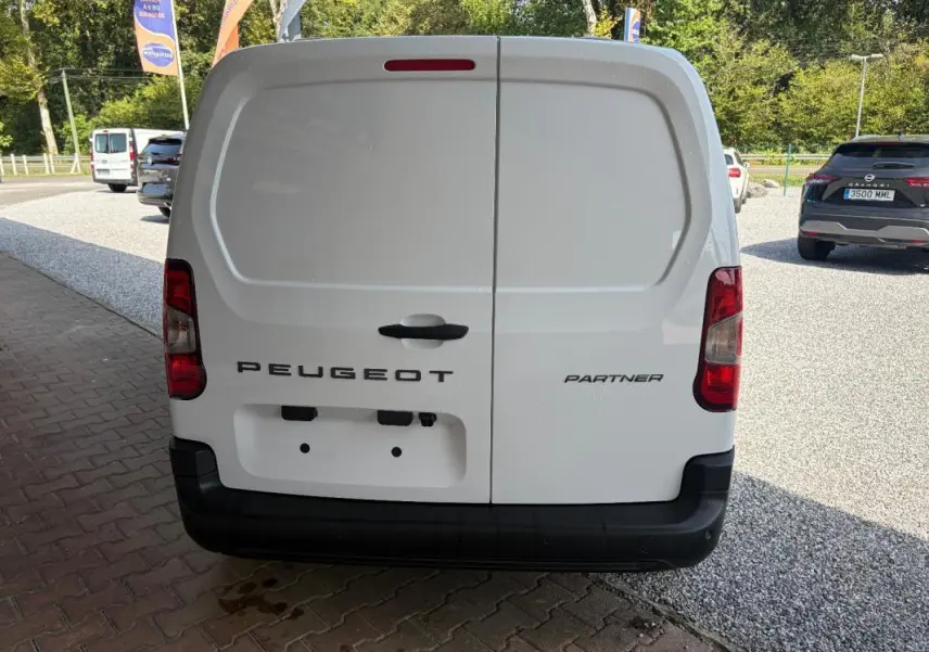 Vue arrière d’un Peugeot Partner blanc, fourgon utilitaire avec portes battantes et feux arrière verticaux.
