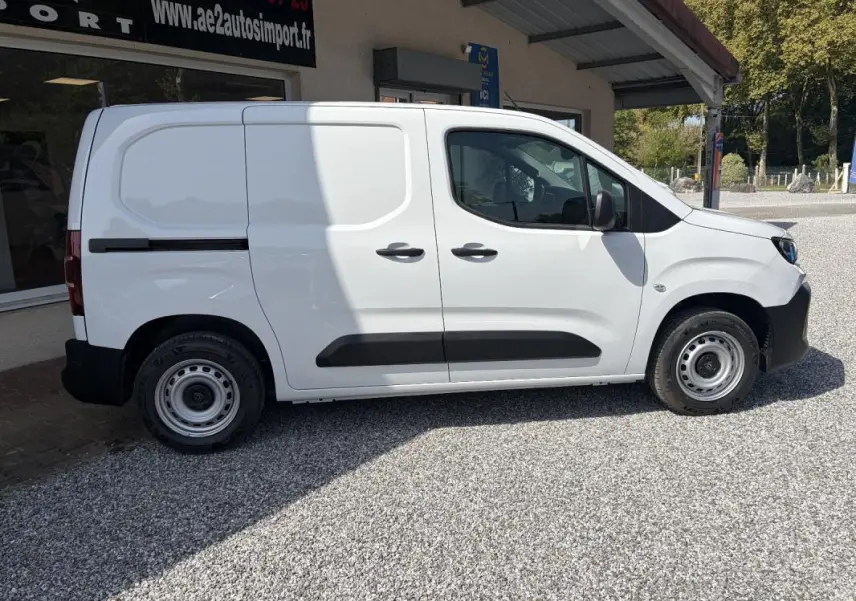 Peugeot Partner blanc vu de profil côté droit, fourgon utilitaire avec protections noires et jantes acier.
