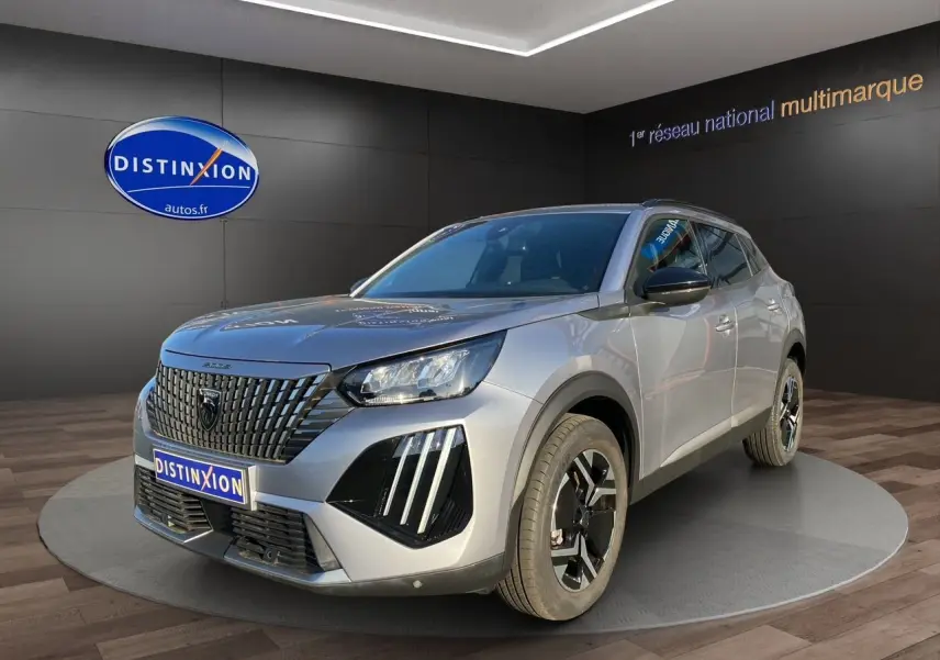 Peugeot 2008 gris Artense vue 3/4 avant droit, mettant en valeur sa calandre noire distinctive et ses phares LED.