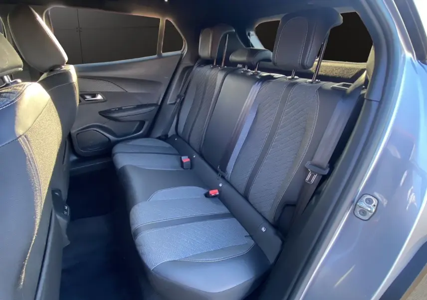 Vue intérieure arrière droite des sièges en tissu et cuir noir du Peugeot 2008 gris Artense 2024, version diesel automatique.