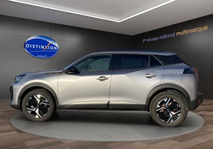Peugeot 2008 gris Artense vue de profil côté gauche, avec jantes noires et toit foncé en intérieur showroom.