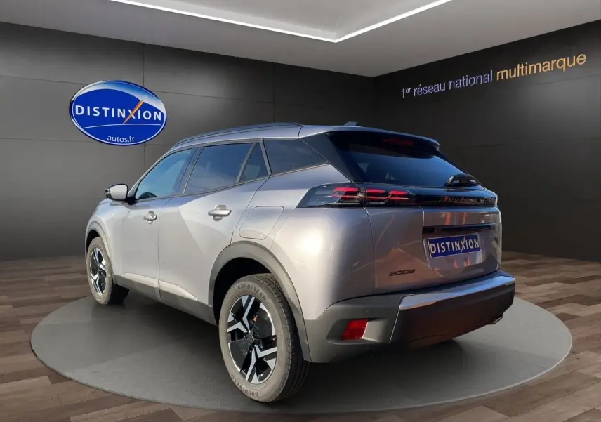 Vue 3/4 arrière droite d'un Peugeot 2008 gris Artense 2024 avec jantes noires et feux arrière LED distinctifs.