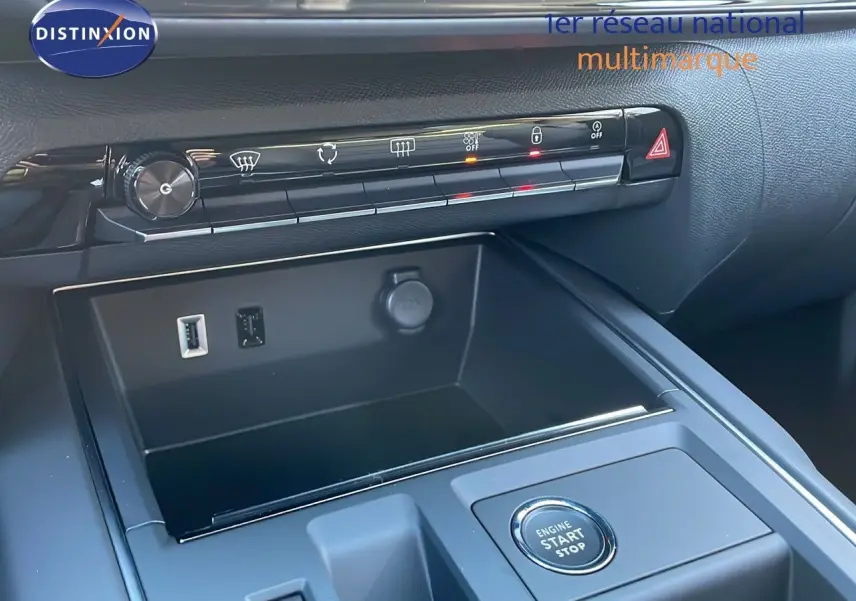 Gros plan sur la console centrale noire du Citroën C5 Aircross 2025, avec bouton start/stop et commandes climatisation.
