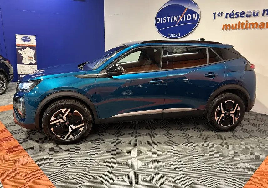Vue de profil côté gauche d’un Peugeot 2008 Allure Hybrid 145 en Bleu Obsession, avec jantes distinctives et toit noir.