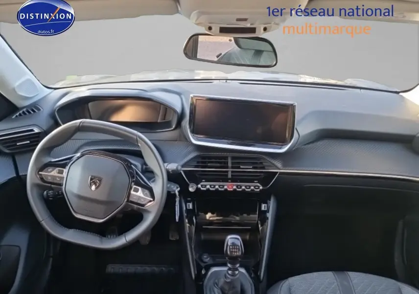 Intérieur de la Peugeot 208 2024 gris sellenium, vue frontale du tableau de bord et volant compact avec boîte manuelle.