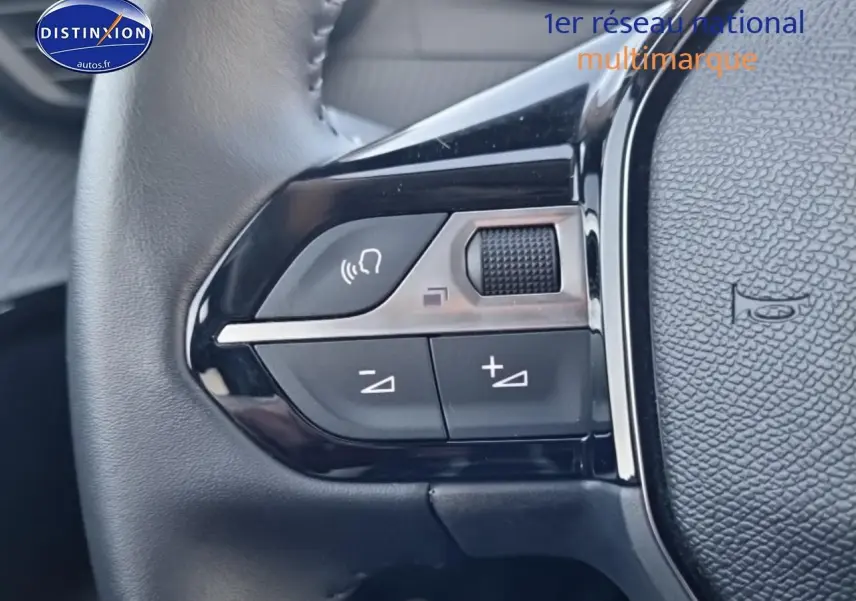 Gros plan sur les commandes audio au volant de la Peugeot 208 gris Selenium e, version 2024, côté gauche.