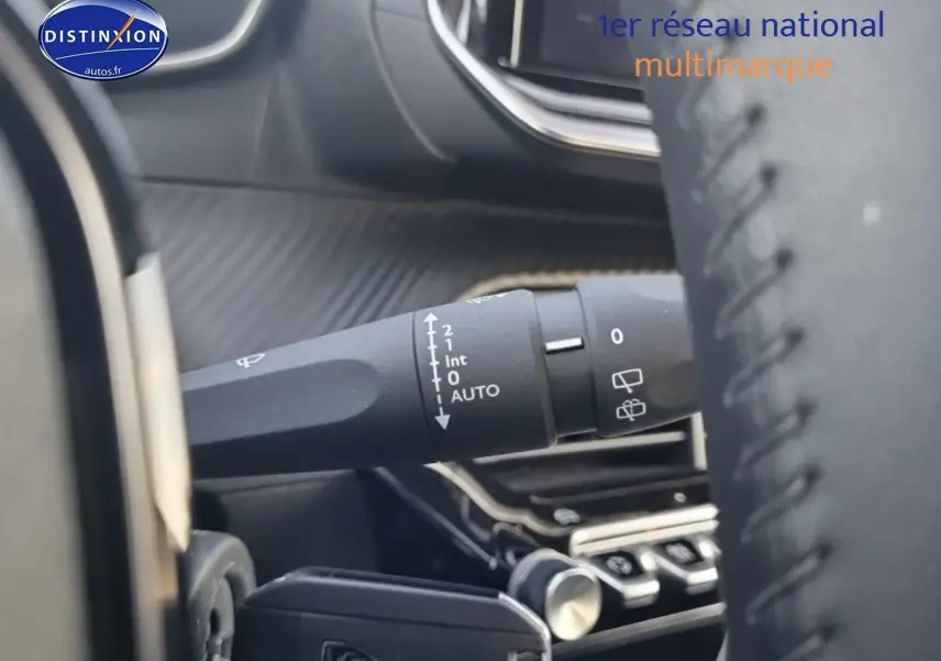 Gros plan sur la commande d’essuie-glace côté gauche du tableau de bord d’une Peugeot 208 gris sélénite 2024.