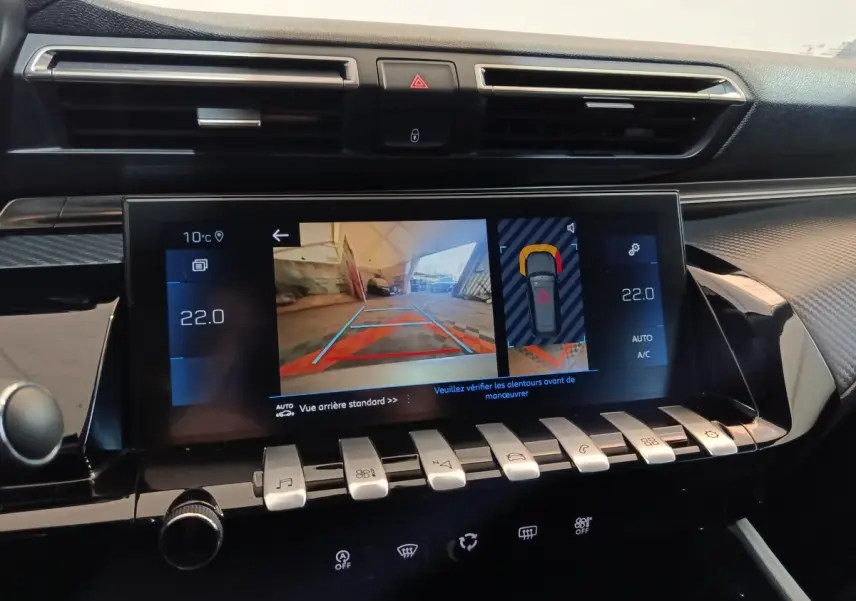 Vue rapprochée de l’écran tactile central de la Peugeot 508 gris clair, affichant la caméra de recul et les réglages climatisation.