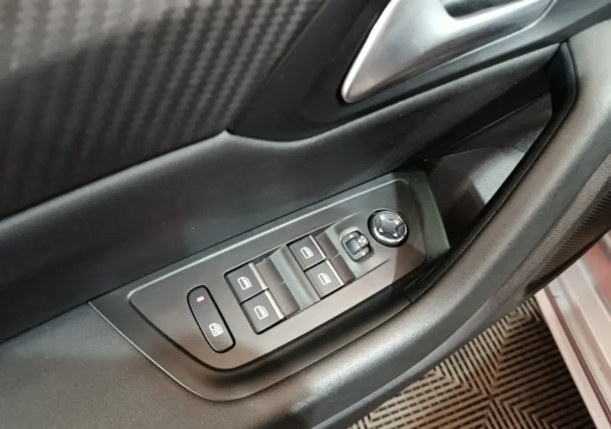 Détail des commandes des vitres et rétroviseurs sur la porte côté conducteur d'une Peugeot 508 gris clair 2020.