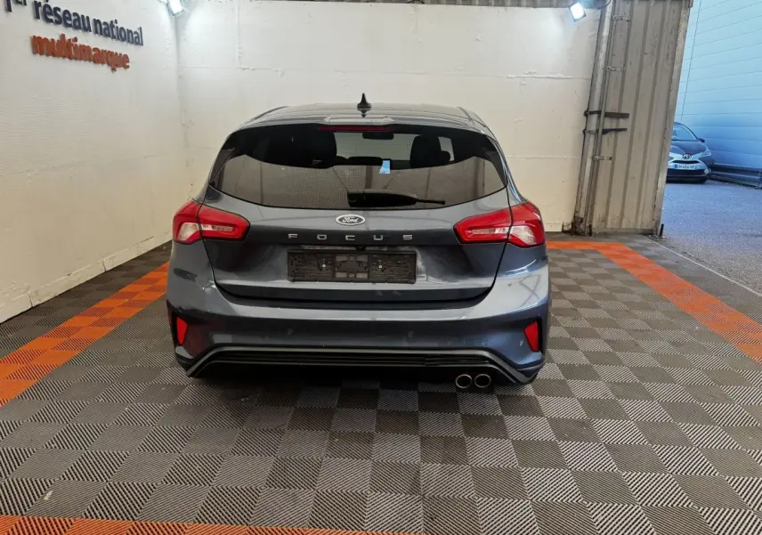 Vue arrière d'une Ford Focus bleu foncé 5 portes avec double sortie d'échappement et feux arrière LED.
