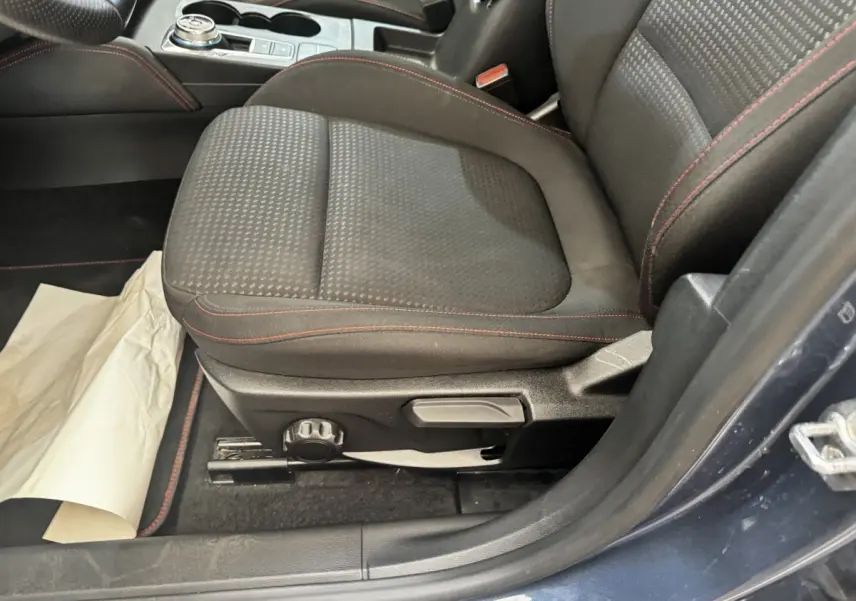 Vue rapprochée du siège avant gauche noir avec surpiqûres rouges de la Ford Focus St-Line bleu 2022.