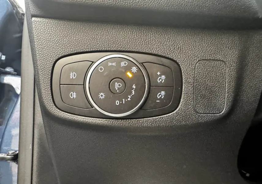Gros plan sur le panneau de commande des phares à gauche du tableau de bord d’une Ford Focus bleu 5 portes 2022.