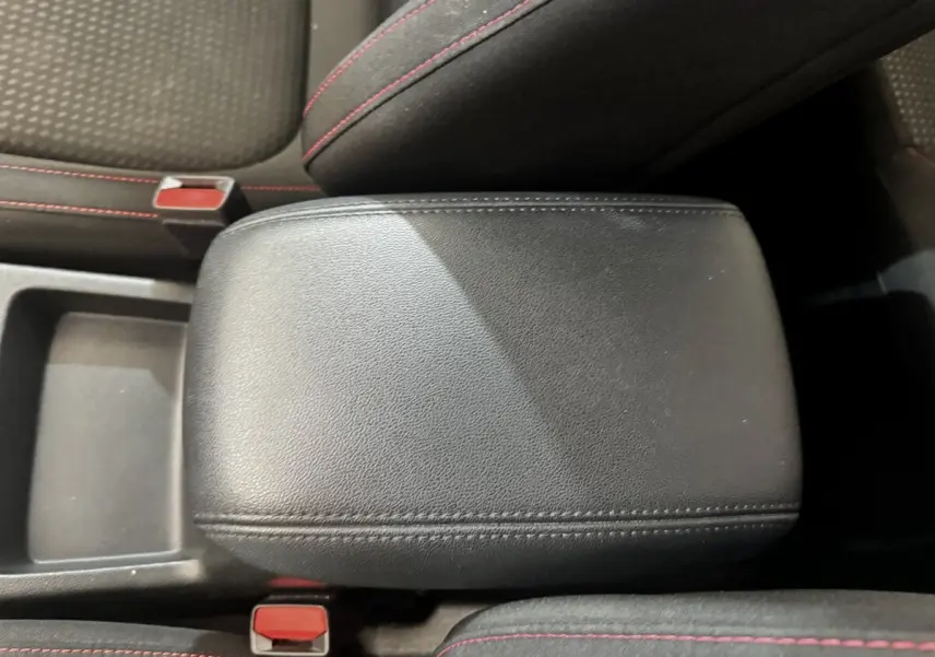 Gros plan sur l'accoudoir central avant en cuir noir avec surpiqûres rouges de la Ford Focus St-Line 2022.