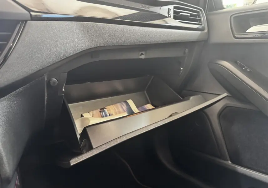Intérieur de la Ford Focus 5P 2022, vue sur la boîte à gants ouverte côté passager avec tableau de bord noir.