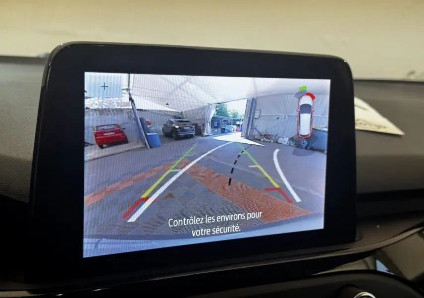 Écran tactile intérieur montrant la caméra de recul avec guidage dynamique d'une Ford Focus bleu 2022.
