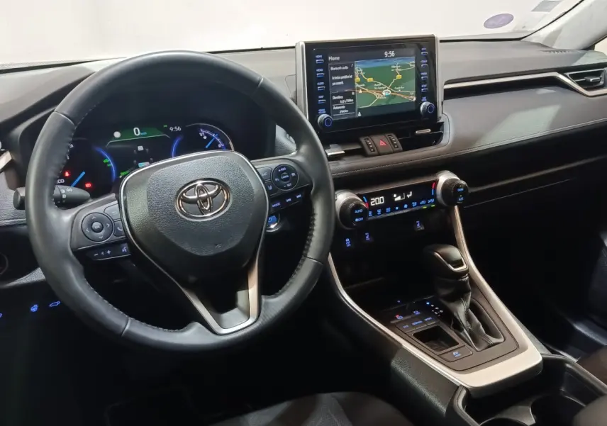Vue intérieure du tableau de bord et volant du Toyota RAV4 Hybride 2WD 218ch avec écran tactile central et commandes au volant.