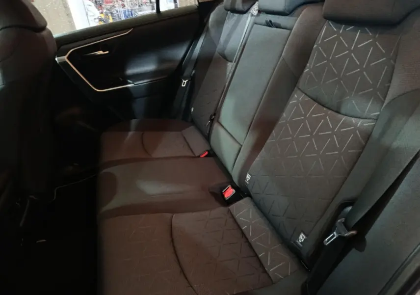 Vue latérale intérieure montrant la banquette arrière noire du Toyota RAV4 Hybride 2WD 2021 avec motifs géométriques.