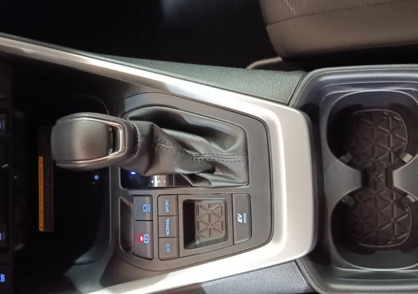 Vue rapprochée de la console centrale du Toyota RAV4 Hybride 2WD 218ch 2021 avec levier de vitesse et commandes de mode de conduite.