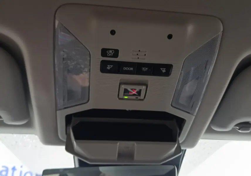 Vue en contre-plongée du plafonnier gris clair du Toyota RAV4 Hybride 2021 avec commandes d’éclairage et compartiment ouvert.
