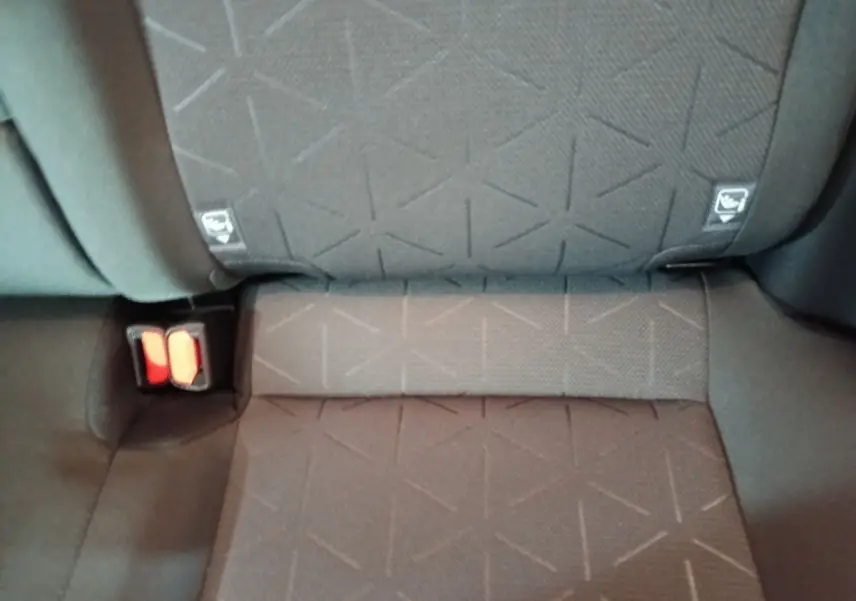 Gros plan sur la banquette arrière grise du Toyota RAV4 hybride, montrant les ceintures de sécurité et les fixations Isofix.