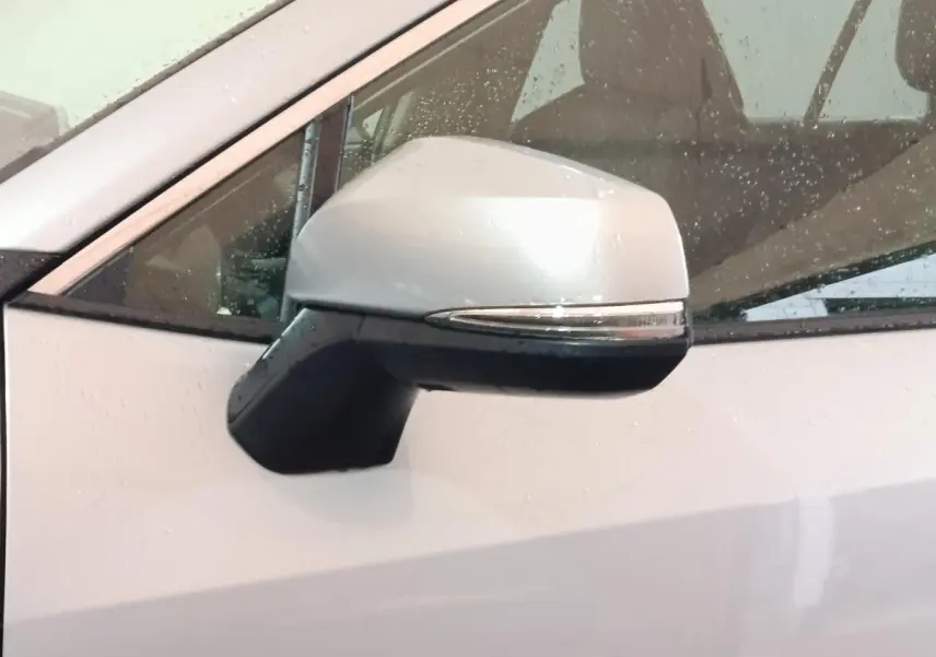 Rétroviseur droit blanc du Toyota RAV4 hybride 2WD 2021, avec clignotant intégré et gouttes de pluie visibles.