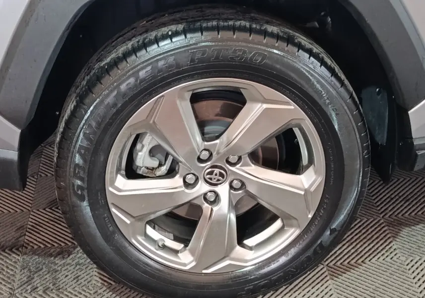 Gros plan sur la roue avant droite du Toyota RAV4 hybride 2021, jante alliage argentée et pneu Dunlop noir.